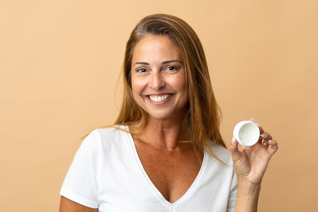 Foto mujer brasileña de mediana edad aislada con crema hidratante y felicidad