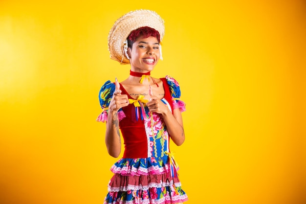 Mujer brasileña con ropa de festa junina Arraial Fiesta de San Juan apuntando a la cámara