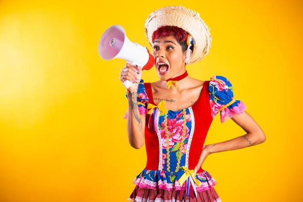 Mujer brasileña con ropa de festa junina Arraial Fiesta de San Juan con cuaderno con megáfono