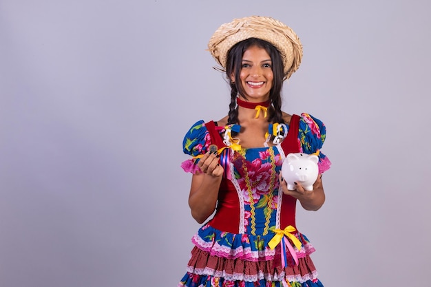 Mujer brasileña con ropa de festa de sao joao festa junina Con alcancía y moneda