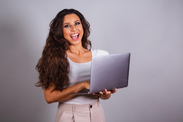 Mujer brasileña sosteniendo un cuaderno navegando por los sitios web informatización Internet