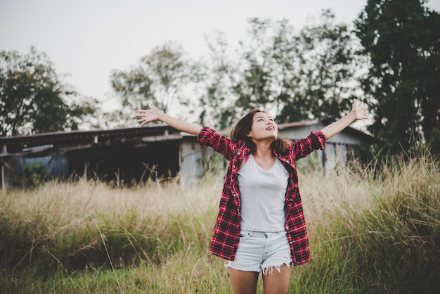 Foto mujer con los brazos levantados de pie en el campo