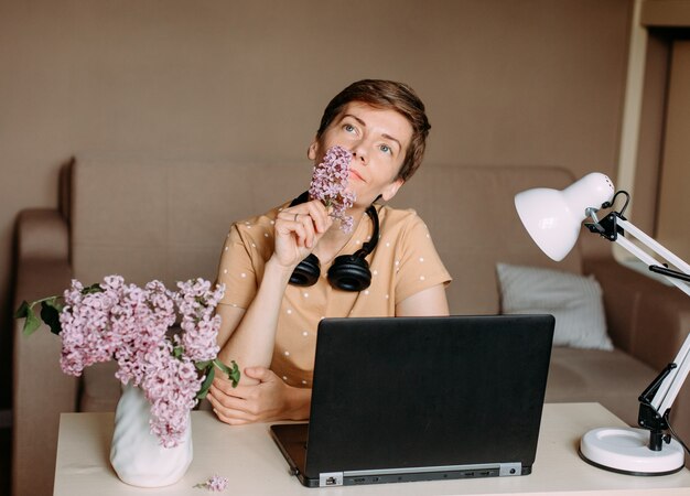 Foto mujer en brillante oficina en casa trabajando portátil