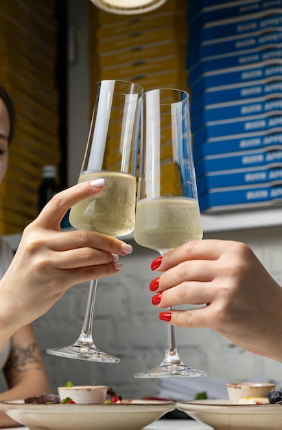 Una mujer brinda con dos copas de vino.