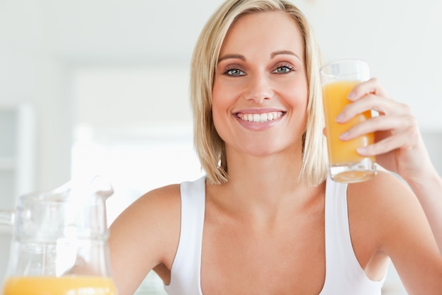 Mujer brindando con jugo de naranja