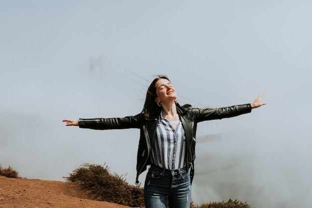 Foto mujer con un brumoso puente golden gate, san francisco