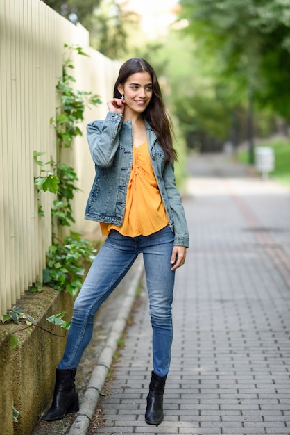 Mujer con buen pelo con ropa casual en el fondo urbano.