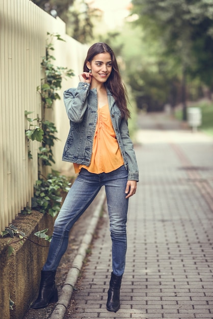 Mujer con buen pelo con ropa casual en el fondo urbano.