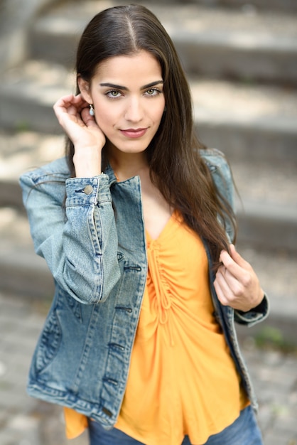 Mujer con buen pelo con ropa casual en el fondo urbano.