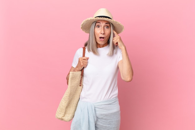 Mujer de cabello blanco de mediana edad que parece sorprendida, dándose cuenta de un nuevo pensamiento, idea o concepto. concepto de verano