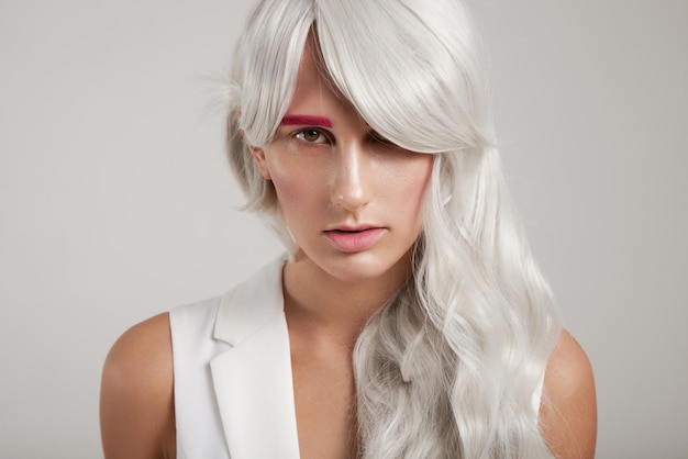 Mujer con cabello de color gris blanco y maquillaje de moda.