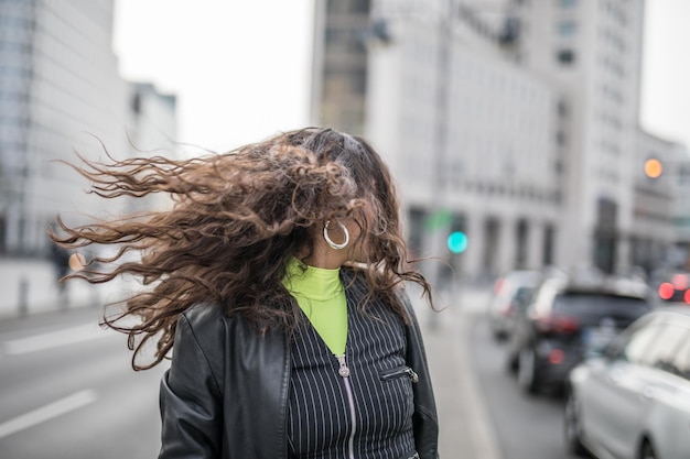 Foto mujer con el cabello desordenado en la ciudad