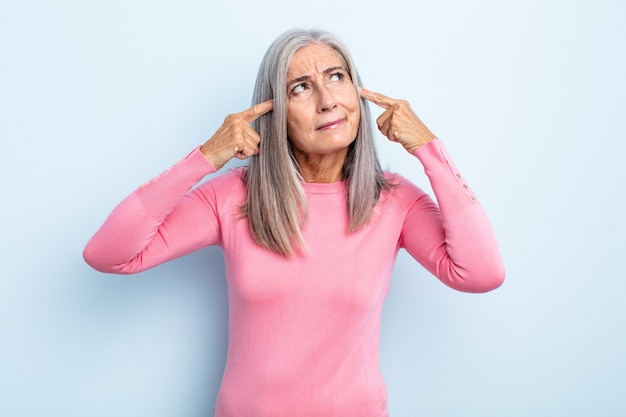 Mujer de cabello gris de mediana edad que parece concentrada y pensando mucho en una idea, imaginando una solución a un desafío o problema