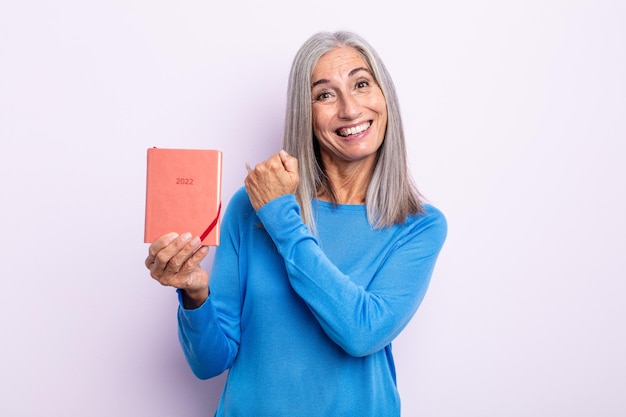 Mujer de cabello gris de mediana edad que se siente feliz y enfrenta un desafío o celebración. Concepto de agenda 2022