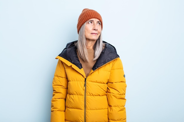 Mujer de cabello gris de mediana edad que se siente triste, molesta o enojada y mirando hacia un lado. concepto de clima frío