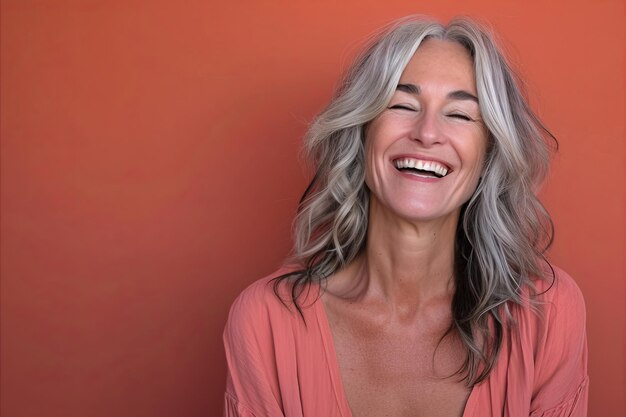 Foto una mujer con cabello gris sonriendo y riendo.