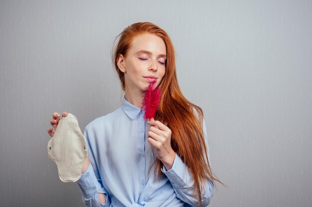 mujer de cabello largo y jengibre pelirroja con juntas orgánicas ecológicas hechas de bioalgodón y tampones desechables.