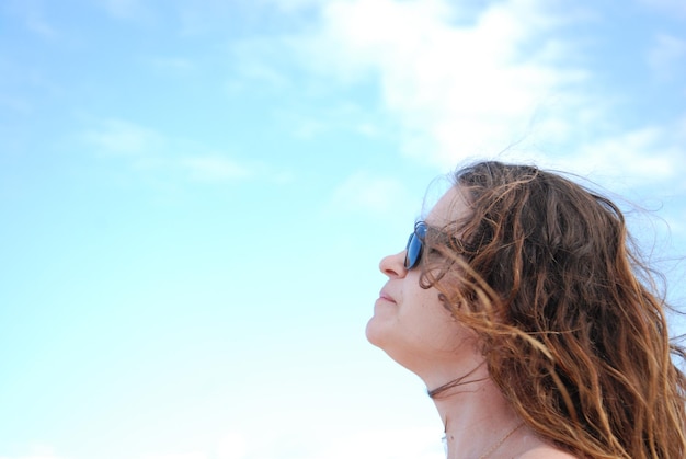 Foto mujer con el cabello largo mirando hacia el cielo