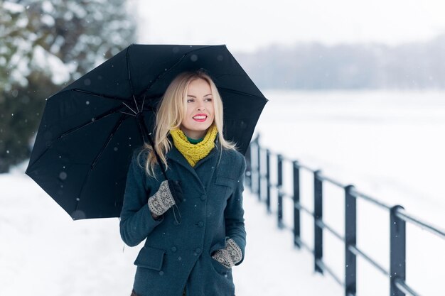 Mujer con cabello largo y rubio en el paisaje de nieve blanca