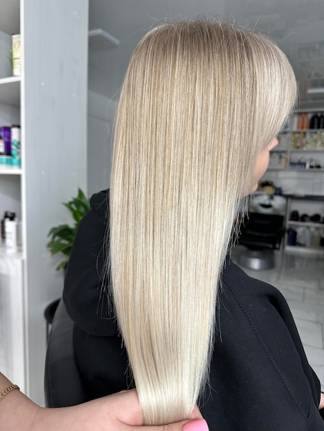 Foto una mujer con cabello largo y rubio en un salón.