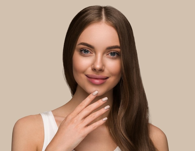 Mujer de cabello largo y saludable con retrato de cara de piel de belleza de cabello largo y rizado. Fondo de color marrón