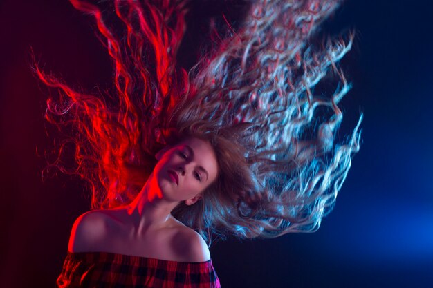 Mujer con cabello en movimiento. Luz de estudio roja y azul