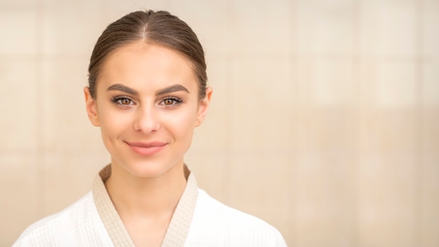 Mujer con cabello oscuro vistiendo bata blanca mirando a la cámara