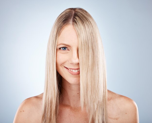 Mujer de cabello y retrato de mujer rubia con cabello saludable para belleza y cuidado del cabello Peinado para el cuidado del cabello y rostro de mujer rubia para cosmetología o bienestar sobre un fondo gris de estudio