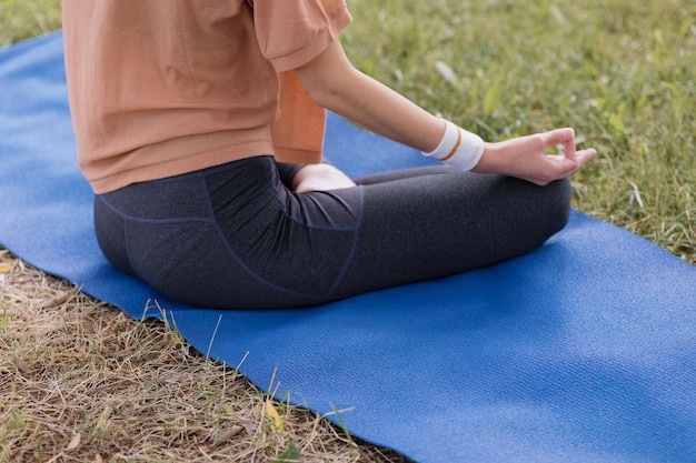 Mujer con cabello rizado medita en un parque yoga y meditación para la salud física y mental