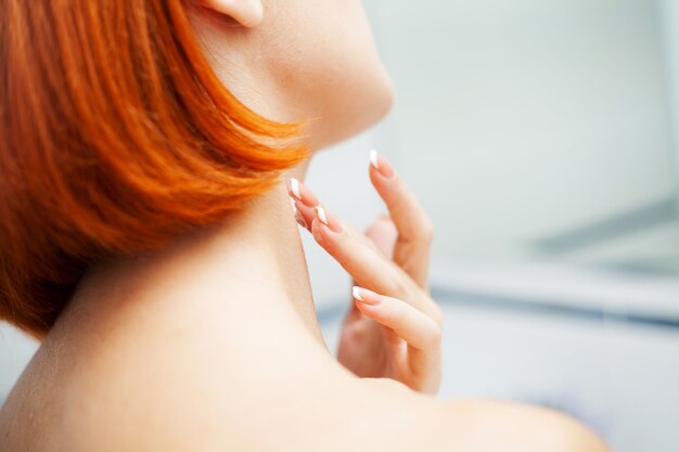 Mujer con cabello rojo en el baño use productos para el cuidado.