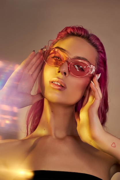 Mujer con cabello rosado y gafas de sol