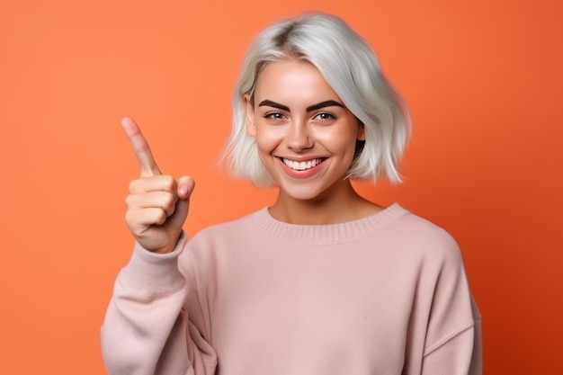 Una mujer de cabello rubio corto y suéter rosa señala con el dedo índice.