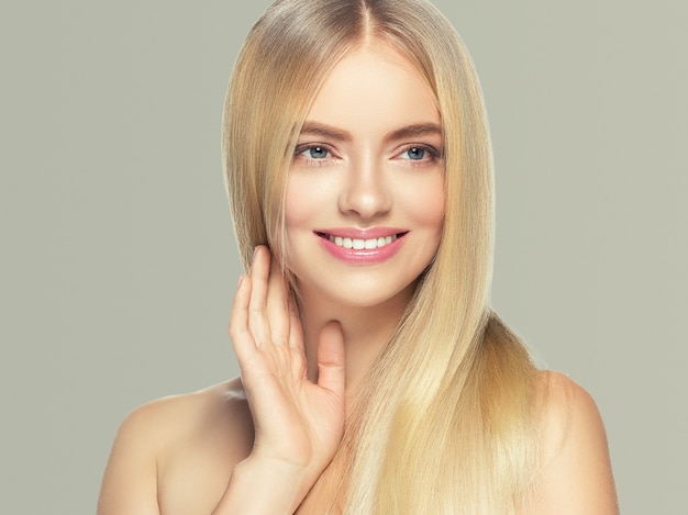 Mujer de cabello rubio piel natural belleza femenina dientes sanos sonrisa. Tiro del estudio.