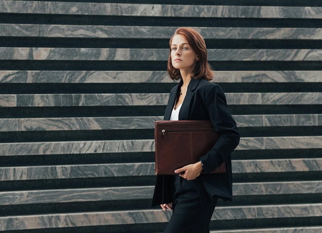 La mujer con el cabello rubio va a una reunión corporativa.