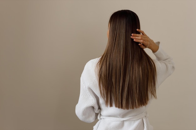 Mujer con cabello sano en albornoz blanco vista trasera Higiene frescura limpieza después de la ducha Efecto de productos cosméticos para el cuidado del cabello y el cuerpo Cuidado cosmético del cuerpo