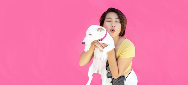 Mujer con cachorro jack russel abraza con amor perro cuida de mascota viste ropa informal en amarillo copia de fondo aislado espacio para su promoción