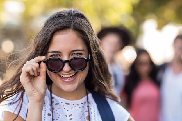 Mujer de cadera con gafas de sol sonriendo a la cámara