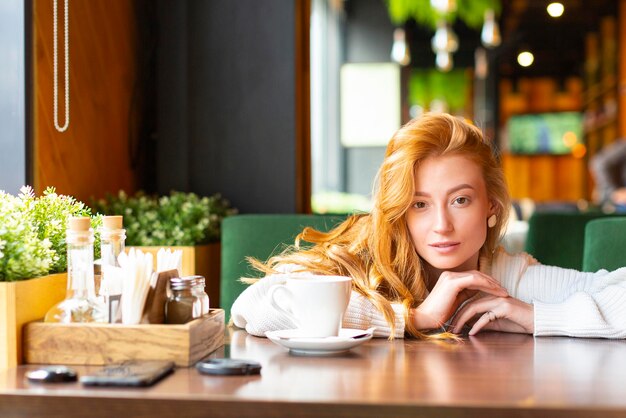 Mujer en un café bebe té o café