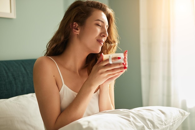 Mujer con café en la cama