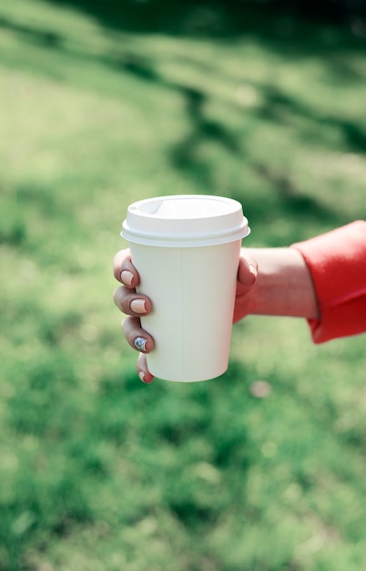 Mujer con café para llevar en el parque