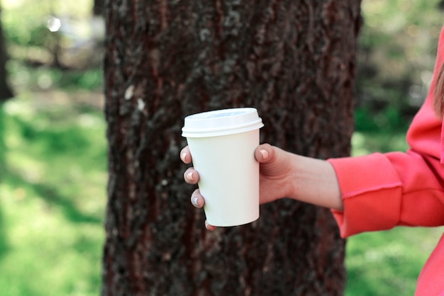 Mujer con café para llevar en el parque