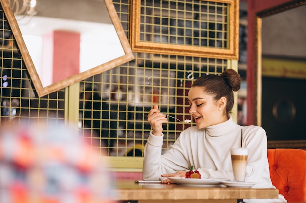 Mujer con café y postre en un café