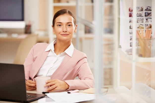 Mujer con café en su lugar de trabajo