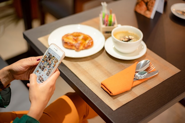 Mujer en café con su smartphone