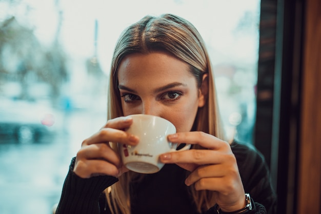 mujer en un café tomando café