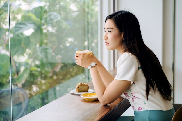 Mujer en una cafetería tomando café