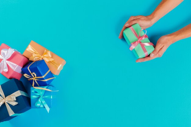 Mujer con caja de regalo sobre fondo de color