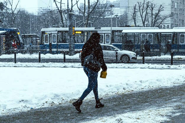 Mujer en la calle en invierno cubierto de nieve