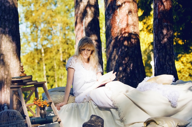 Mujer en una cama en el bosque