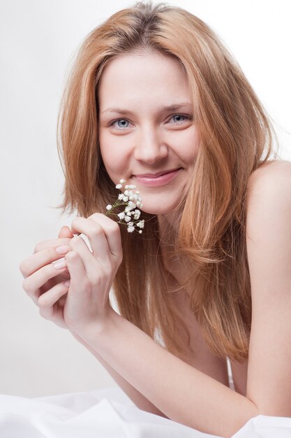 Mujer en la cama con una flor